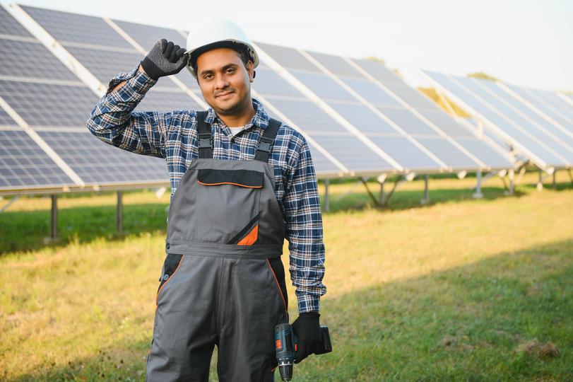 Technician inspecting solar panels on a residential roof in UK