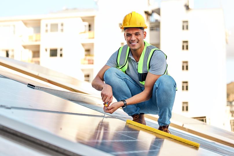 Technician inspecting solar panels on a residential roof in UK