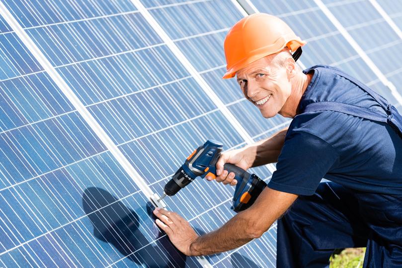 Technician inspecting solar panels on a residential roof in UK