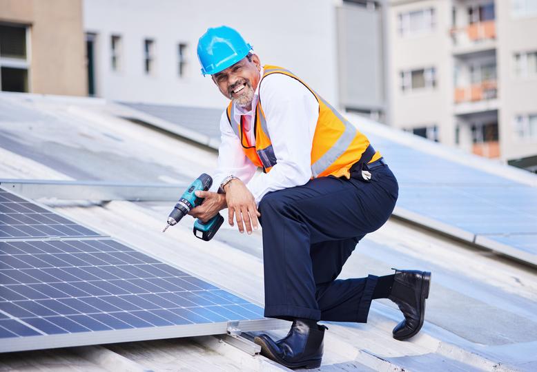 Technician inspecting solar panels on a residential roof in UK