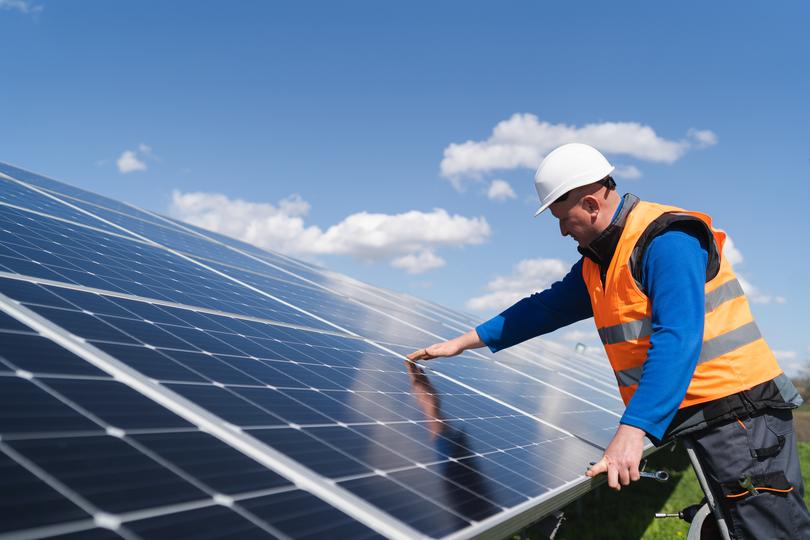 Technician inspecting solar panels on a residential roof in UK