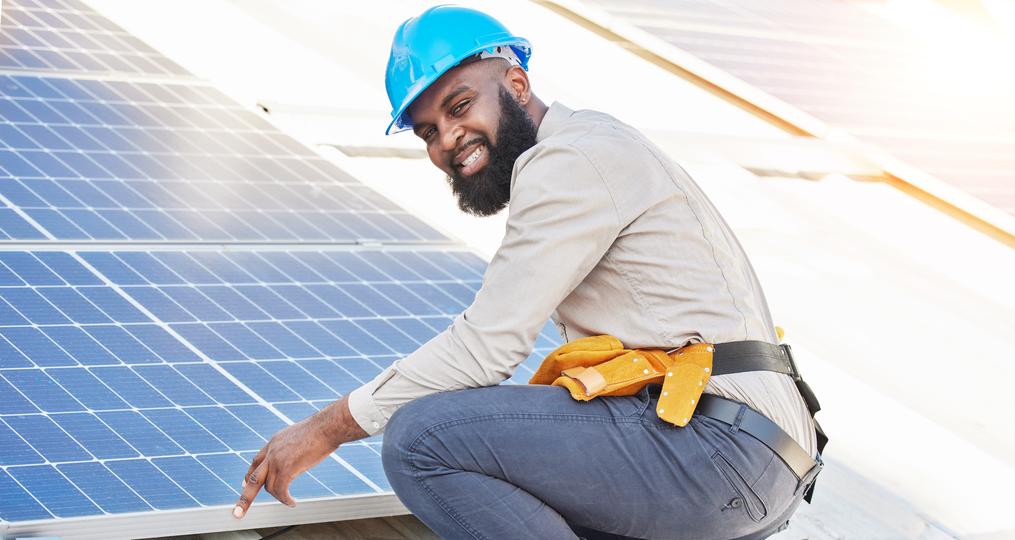 Technician inspecting solar panels on a residential roof in UK